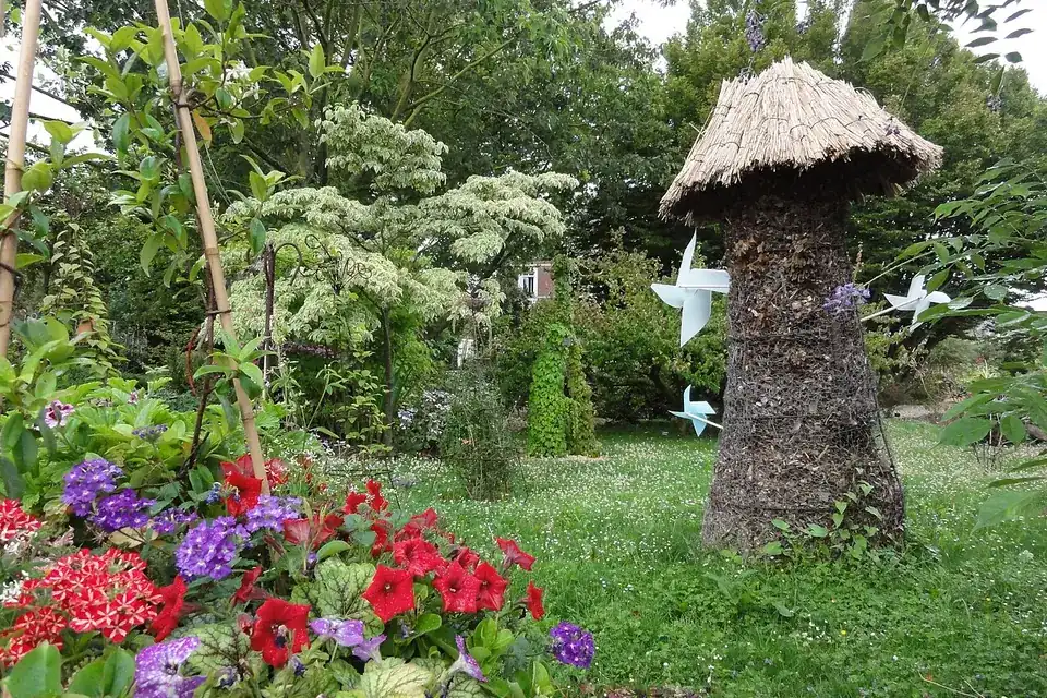 Massifs fleuris et sculpture en bois dans le jardin d'un centre de formation horticole