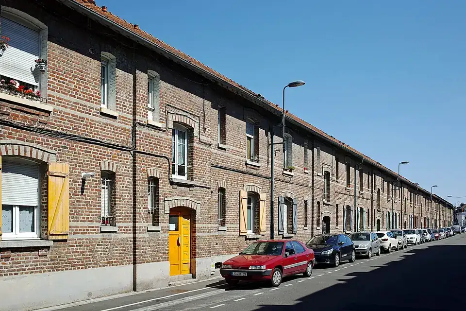 Rangée de maisons ouvrières en brique rouge alignées le long d'une rue